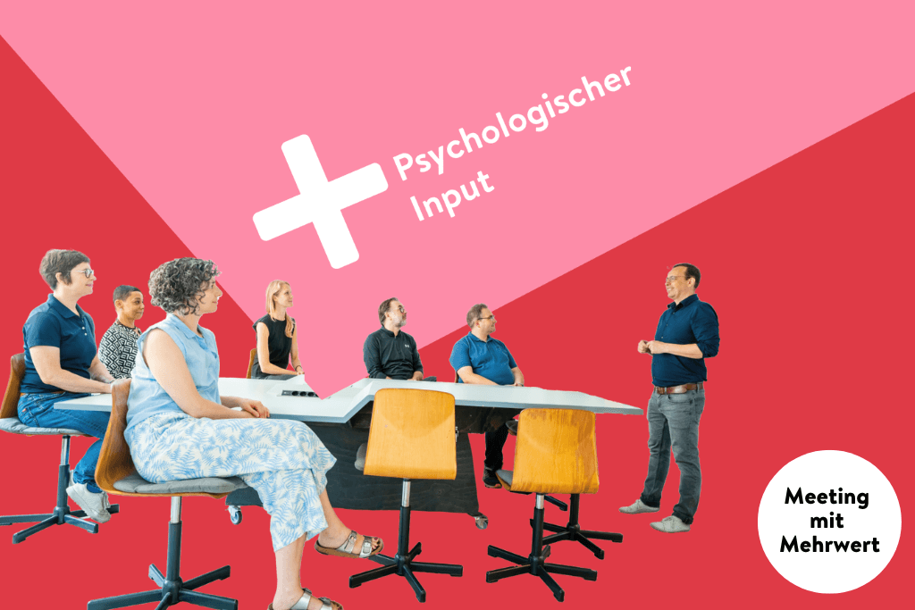 Meeting mit Mehrwert (psychologischer Input): vor rosa-rotem Hintergrund sitzt eine Personengruppe um einen Tisch herum. Vorn steht ein weißer Mann und spricht.